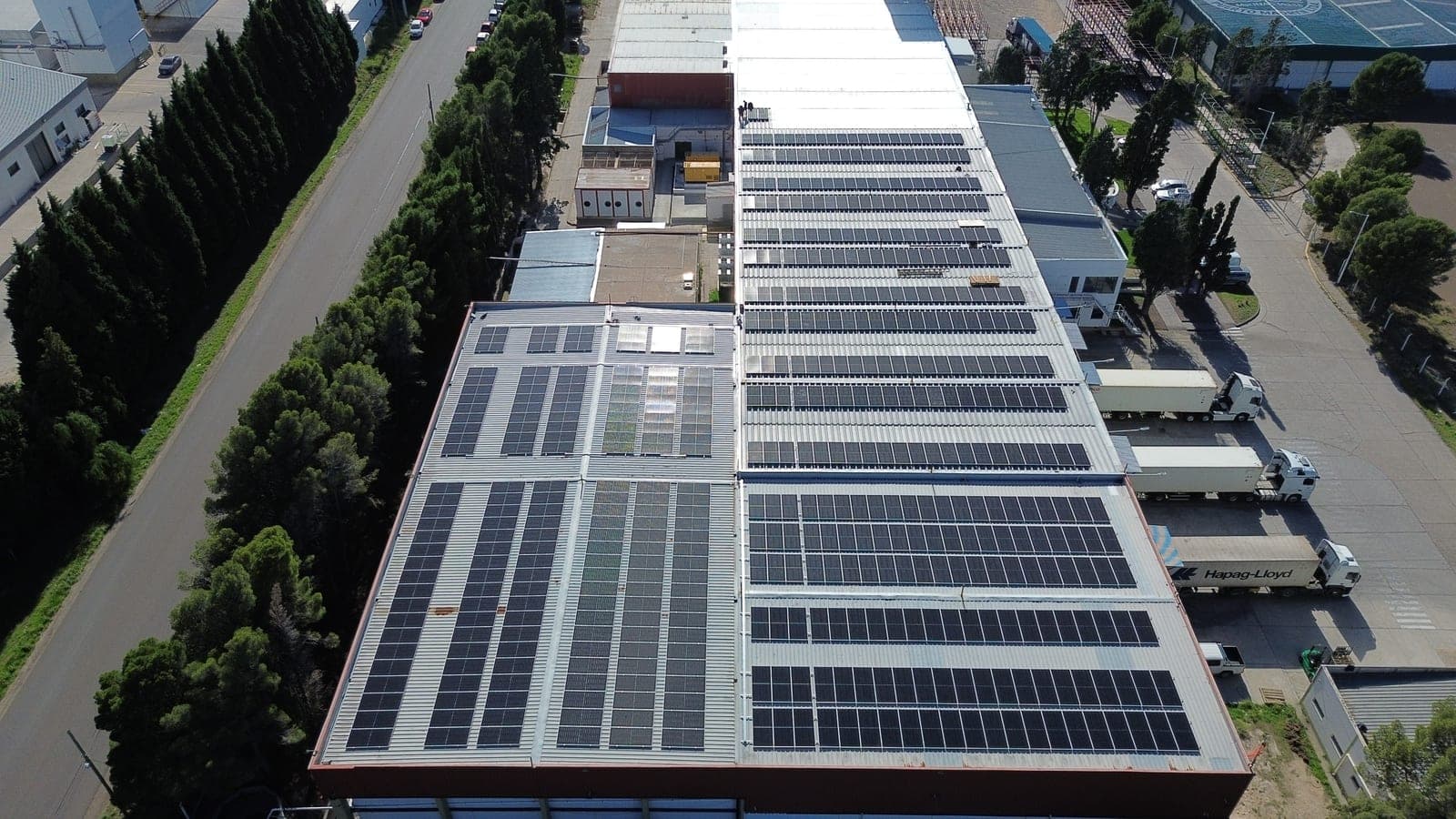 Vista aérea de una nave industrial en la Patagonia con el techo íntegramente cubierto de paneles fotovoltaicos instalados por el grupo
