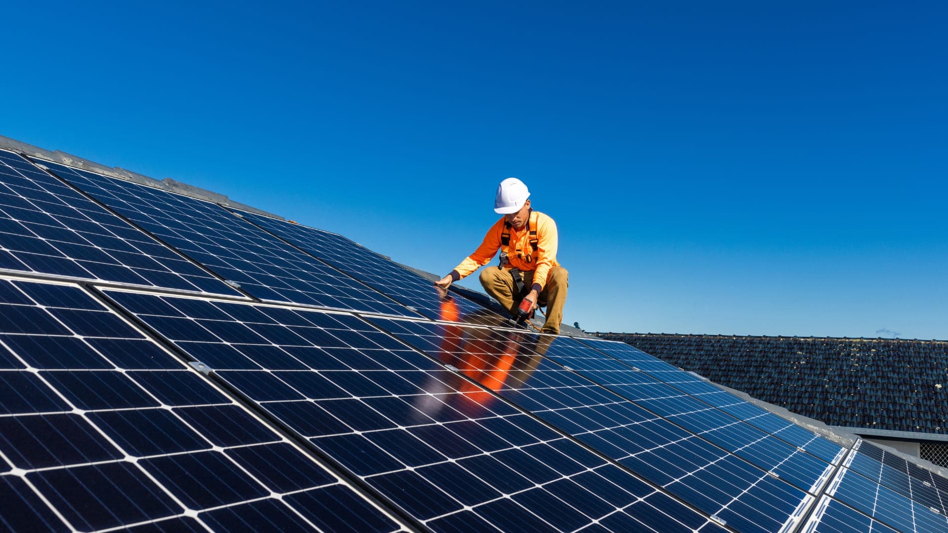 Técnico de Península Energía y Servicios trabajando sobre un techo con paneles fotovoltaicos